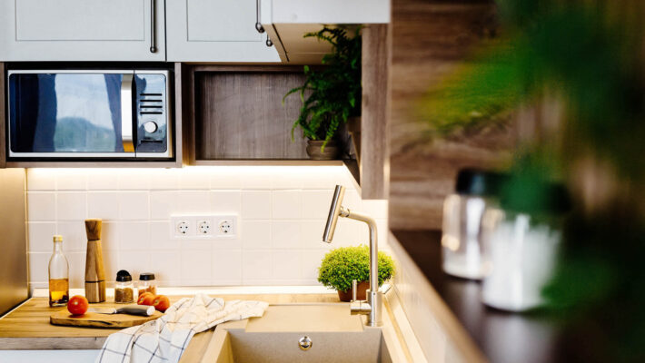 Kücheneinrichtung mit modernen Möbeln und Geräten und Wasserfilter in der Küche aus rostfreiem Stahl