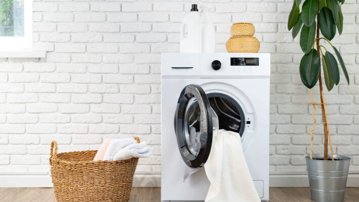 Waschmaschine ohne Kalkschutzverkalkt und Korb in einer Waschküche